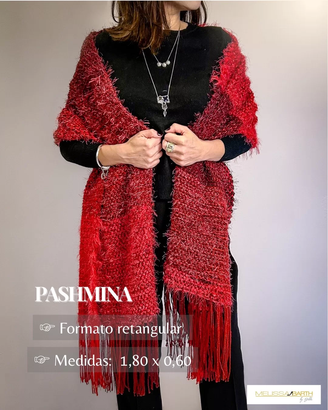 Foto de uma modelo usando uma pashmina vermelha luxuosa e exuberante com o texto dentro da imagem informando as medidas de 1.80 por 0.60 e formato retangular